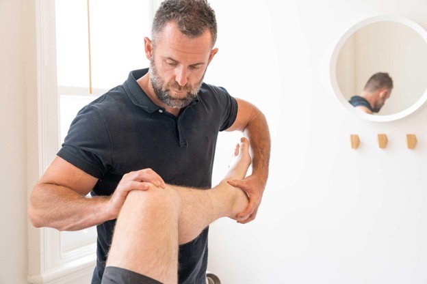 Physiotherparist tending to a leg in the air